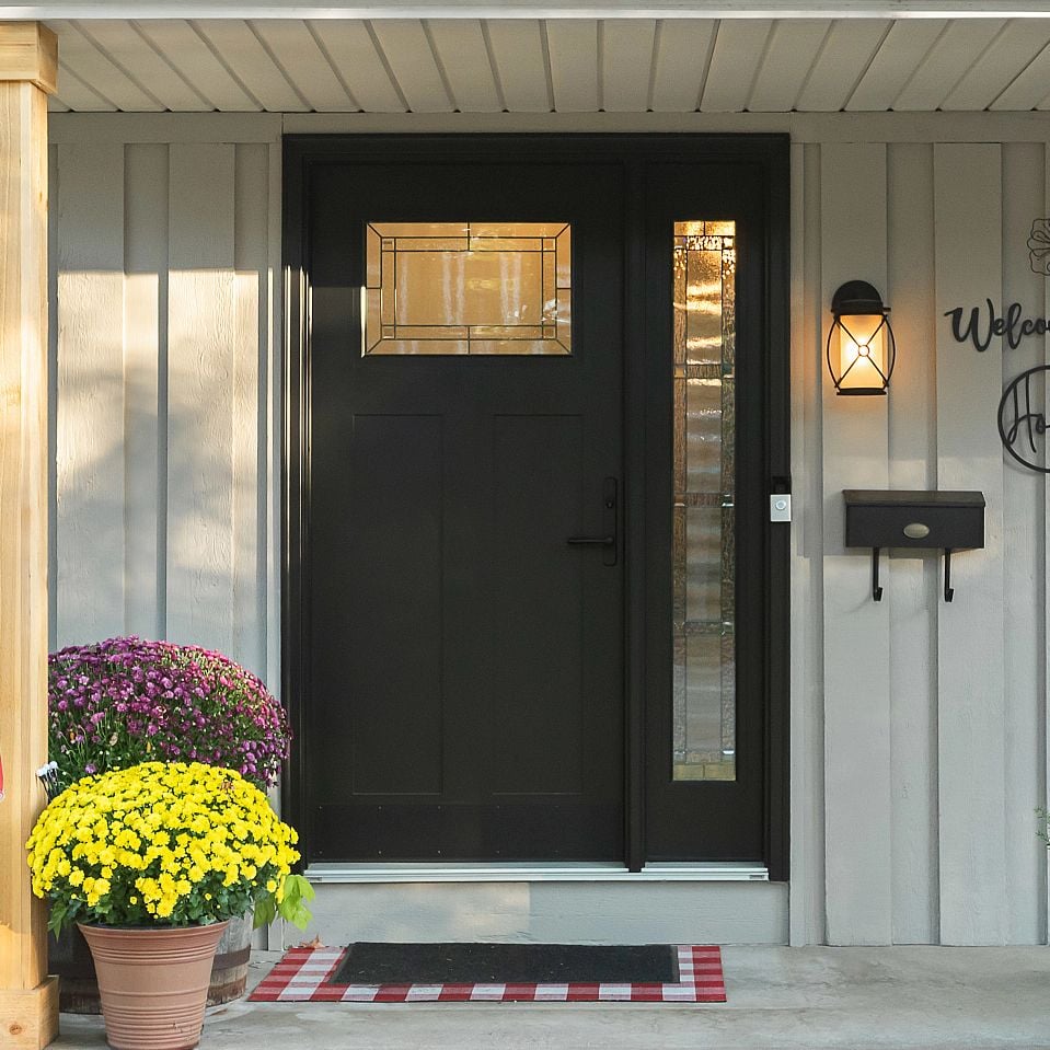 A single panel Ensemble entry door. It has one sidelight to the right. The door has a decorative art glass panel at the top.