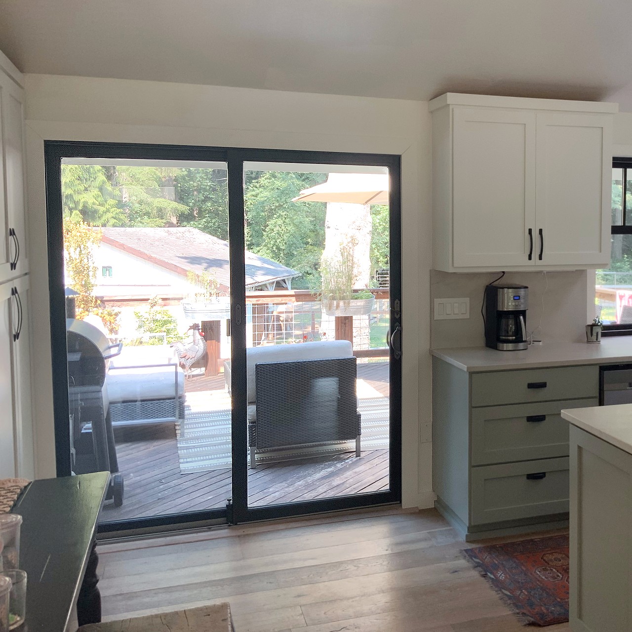 A black modern sliding glass door in a newly remodeled kitchen.