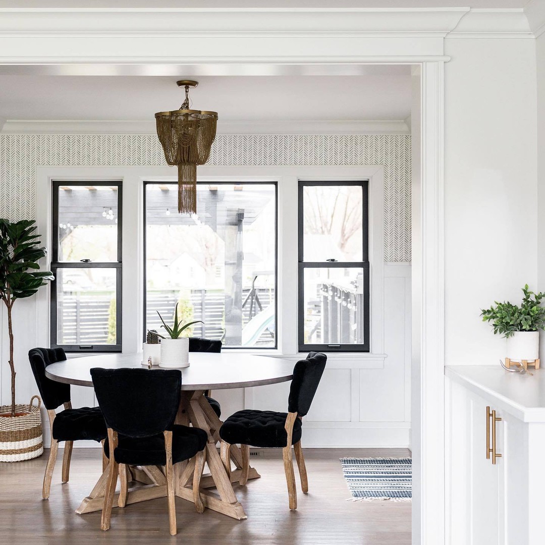 A dining room with a picture window flanked by double hungs